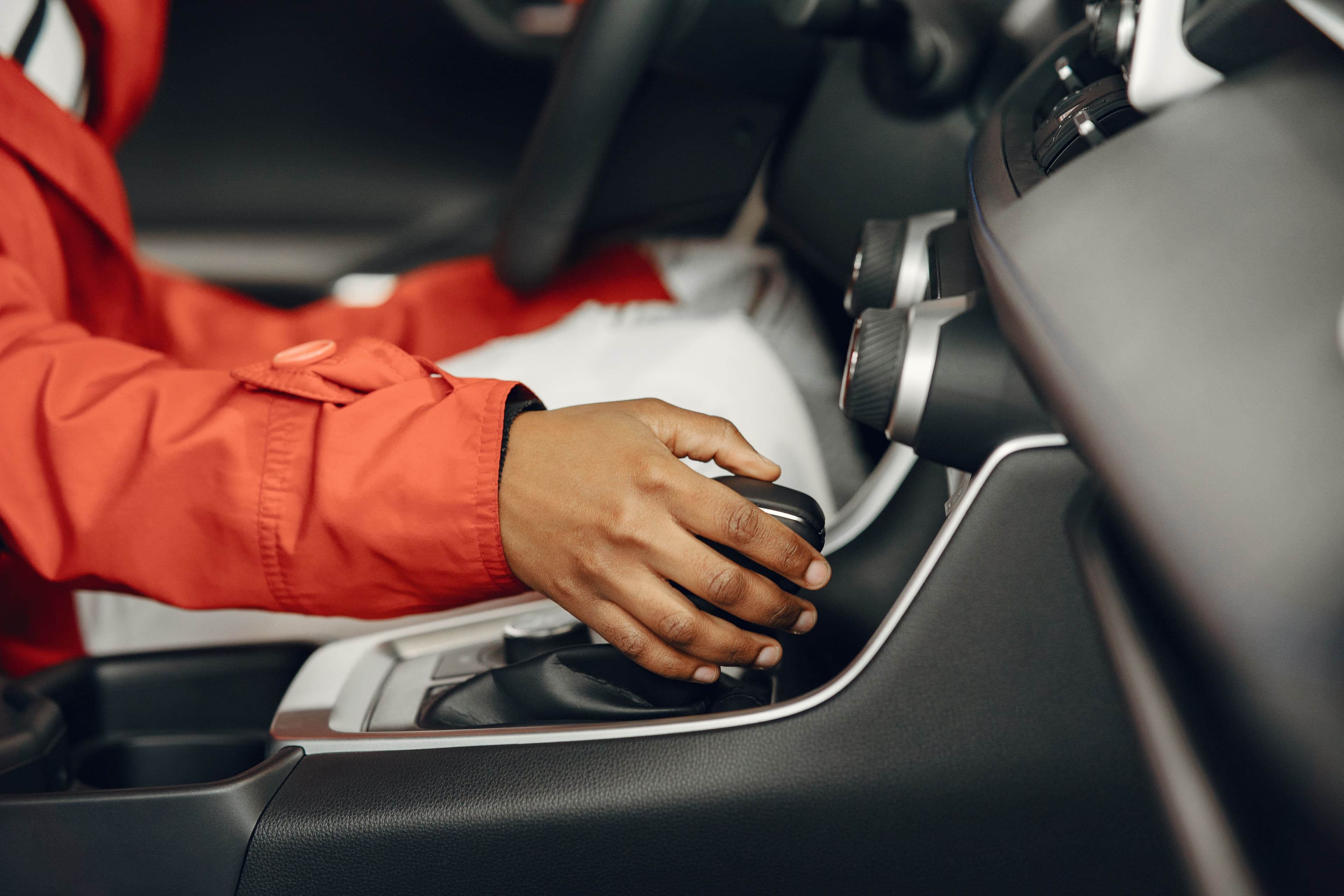 Motorista com a mão na alavanca de um câmbio automático