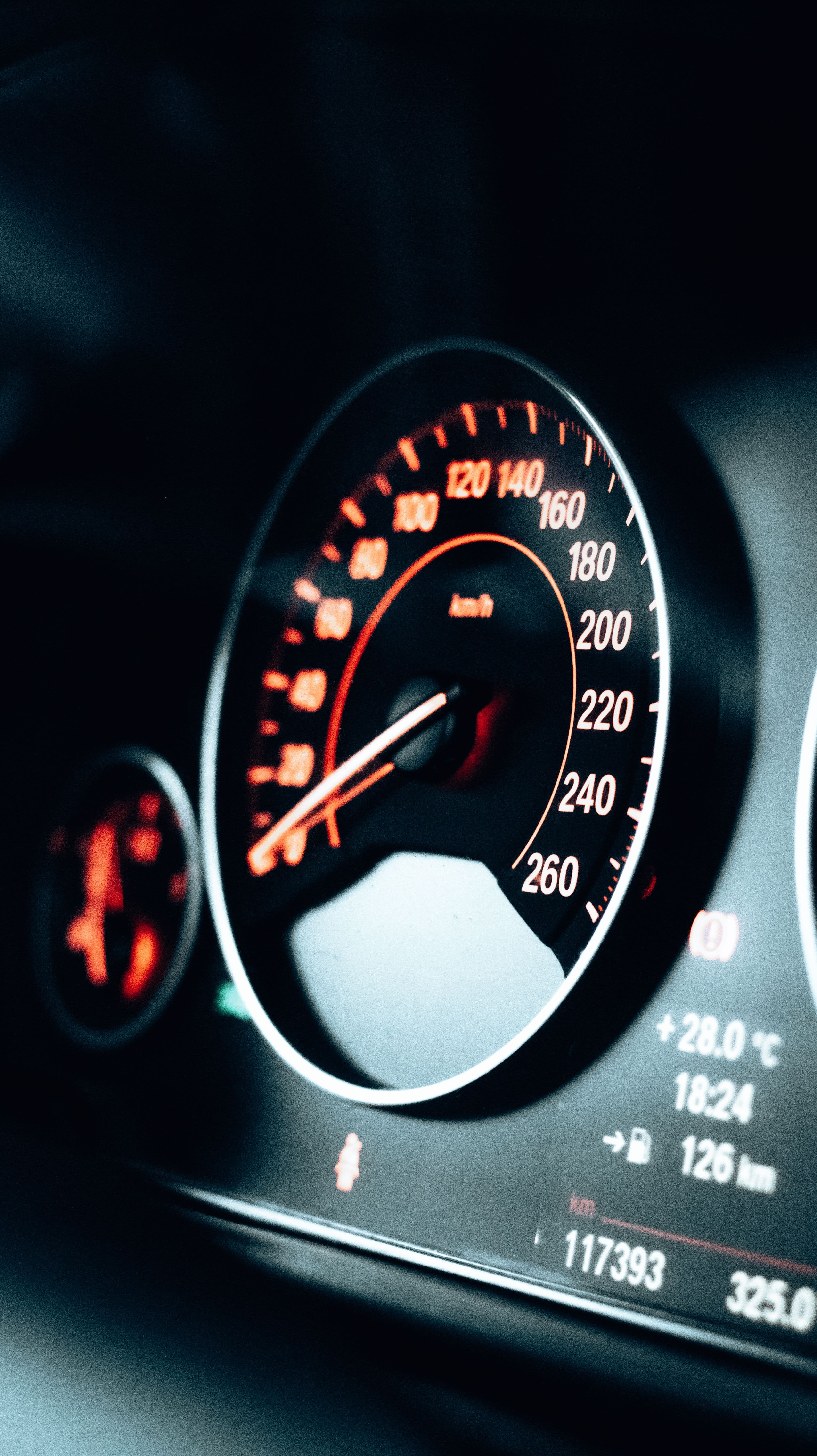Painel de instrumentos de um carro com o velocímetro e uma luz de alerta acesa